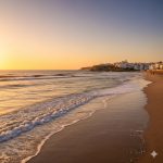 Escapada fin de semana playa Andalucía con atardecer en la costa y arena dorada